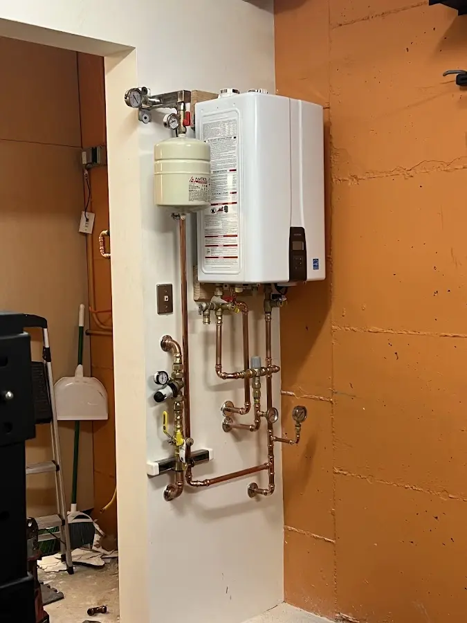 Plumbing technician inspecting water heater connections in Deptford